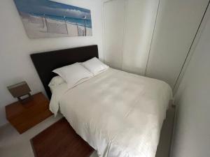 a bedroom with a white bed and a picture of a beach at Apartment in Algarve,Vilamoura in Vilamoura +31 photos