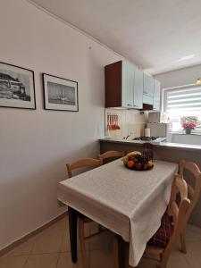 a kitchen with a table with a bowl of fruit on it at Tramonto in Medulin