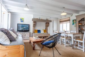 ein Wohnzimmer mit einem Sofa und einem Tisch in der Unterkunft Cute Normandy Chaleureuse Maison au Cap Levi in Fermanville