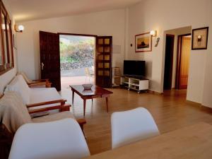 sala de estar con muebles blancos y TV en Los canteros de Belgara, en La Frontera