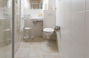 a white bathroom with a toilet and a sink at Muschel 3 in Ahrenshoop +14 photos
