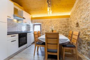 eine Küche mit einem Tisch und Stühlen im Zimmer in der Unterkunft Patakun holiday home for 5, with heated pool in Lećevica