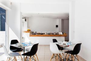 een eetkamer met 2 tafels en witte stoelen bij Elychryson in Chersonissos