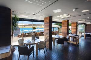 a restaurant with tables and chairs and a view of the ocean at Hotel Aleksandar Rafailovići in Budva