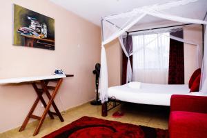 a bedroom with a canopy bed and a red rug at Martha's cozy home near JKIA airport in Nairobi