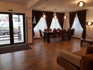 ein Esszimmer mit Tisch und Stühlen in der Unterkunft Sat de Vacanta Martisorul Cacica in Suceava
