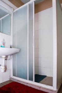 a shower with a glass door next to a sink at Martha's cozy home near JKIA airport in Nairobi