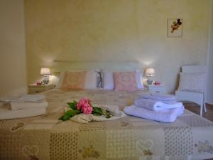 Un dormitorio con una cama con toallas y flores. en LOCANDA MURALES - Turismo rurale, en Olbia