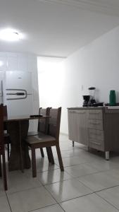 eine Küche mit einem Tisch, Stühlen und einer Theke in der Unterkunft Marcella's Holiday House - 100 mts Praia do Morro in Guarapari