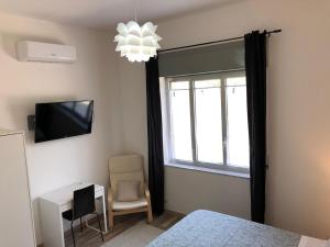 a bedroom with a bed and a window and a tv at Nonna Febronia in Patti +14 photos