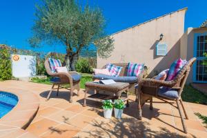 a patio with wicker chairs and a table at YourHouse Son Gallina quiet, private villa in the north of Mallorca in Sa Pobla