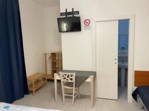 ジュリアノーヴァにあるB&B del Corso - Affittacamere GIULIANOVAの壁にテーブルとテレビが備わる部屋