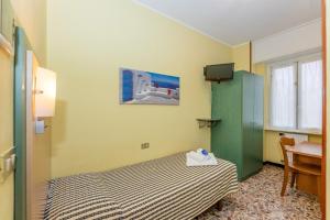 a small bedroom with a bed and a green cabinet at Villa Adriana in Pietra Ligure