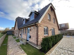 ein Backsteinhaus mit schwarzem Dach in der Unterkunft Haus Oscar in Westerland in Westerland