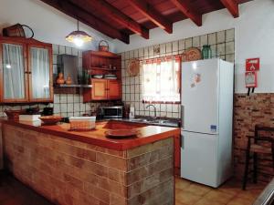 a kitchen with a white refrigerator and a counter at YourHouse Cas Sito in Cala Tuent