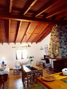 a living room with a table and a stone fireplace at YourHouse Cas Sito in Cala Tuent