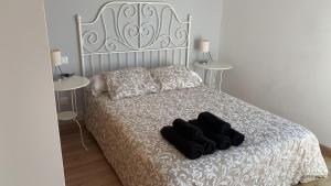 a bedroom with a bed with black gloves on it at Apartamentos en la playa in Villanueva
