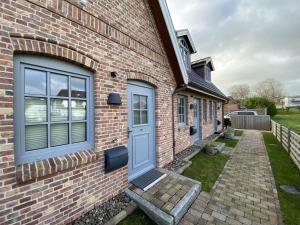 ceglany dom z niebieskimi drzwiami w obiekcie Haus Oscar in Westerland w mieście Westerland