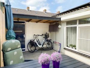 una bicicleta estacionada en una cubierta con dos plantas en Knusse vakantiewoning Domburg DO04, en Domburg