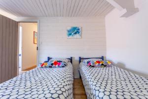 2 nebeneinander sitzende Betten in einem Schlafzimmer in der Unterkunft Cute Normandy Chaleureuse Maison au Cap Levi in Fermanville