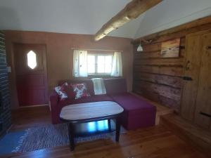 a living room with a purple couch and a window at Toomarahva Farmstay in Altja