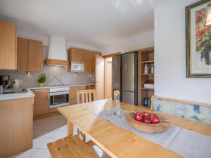 una cocina con una mesa de madera y un bol de fruta. en Appart Klocker, en Kaltenbach