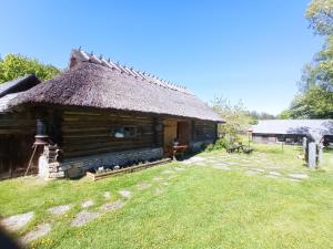 una antigua cabaña de madera con techo de paja en Toomarahva Farmstay, en Altja