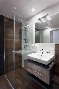 uma casa de banho com um lavatório e um chuveiro em Silver Apartment Old Jewish Quarter em Cracóvia