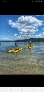 Due persone in kayak gialli in acqua di Ritratto sul Lago B&B a Dormelletto