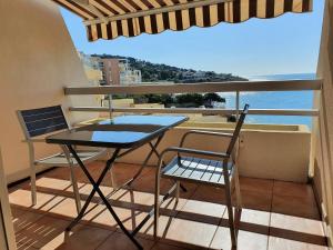 einen Balkon mit einem Tisch, Stühlen und Meerblick in der Unterkunft CONFORTABLE T2 EN FRONT DE MER, PARKING, WI-FI in Sète