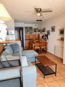 ein Wohnzimmer mit einem Sofa und einem Tisch in der Unterkunft CONFORTABLE T2 EN FRONT DE MER, PARKING, WI-FI in Sète