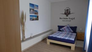 Dormitorio pequeño con cama y cartel en la pared en Alte Tischlerei, en Essel