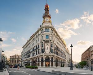 un edificio con una torre dell'orologio sopra di Four Seasons Hotel Madrid a Madrid