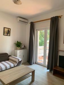 a living room with a bed and a sliding glass door at Apartments Ban in Novi Vinodolski