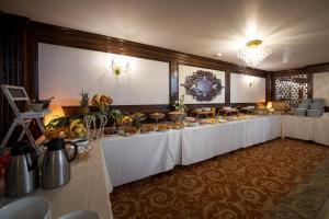 Hotel Silva Busteni في بوستين: طاولة طويلة عليها طعام في غرفة