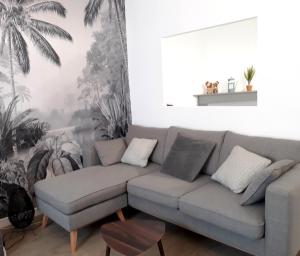 - un salon avec un canapé et une fresque murale de palmiers dans l'établissement MIRA BELLA - Centre ville avec jardin, à Saumur