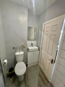 a white bathroom with a toilet and a sink at White Wings in Nuneaton