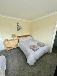 1 dormitorio con 1 cama grande y mesita de noche de madera en White Wings en Nuneaton