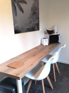 une table en bois avec deux chaises et un four micro-ondes dans l'établissement MIRA BELLA - Centre ville avec jardin, à Saumur