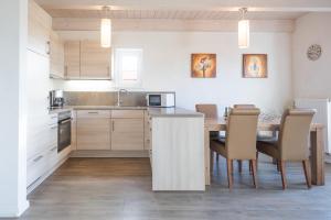 a kitchen with a table and chairs in a room at Ferienhaus Basstölpel in Dagebüll