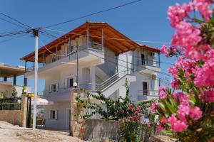 a white building with pink flowers in front of it at Vila Ervin Ksamil in Ksamil