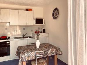 a small kitchen with a table with a vase on it at Appartamento Vasiliki in Porto San Paolo