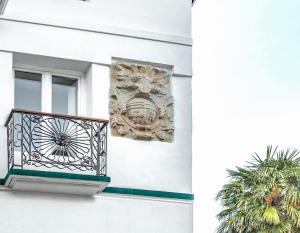 a building with a balcony with a crest on it at SNÖ HOTEL CAMINO do EUME APARTAMENTOS in Puentedeume