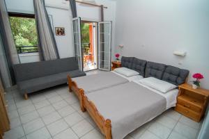 um quarto com uma cama e um sofá em Ampelaki Studios em Boukari