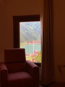 a chair in front of a window with a view at İmera Suite Otel in Uzungol