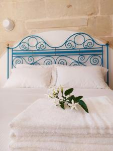 un letto bianco con testiera blu e fiori sopra di Giardino Frannicola a Maglie