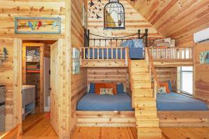 a log cabin bedroom with two bunk beds at Arbor House of Dripping Springs - Finch House in Dripping Springs
