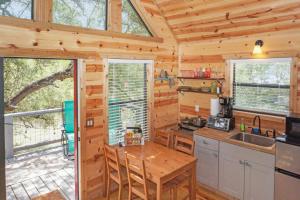 a kitchen in a log cabin with a large window at Arbor House of Dripping Springs - Finch House in Dripping Springs