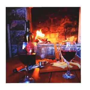 two glasses of red wine next to a fireplace at Rooms Verda in Senj