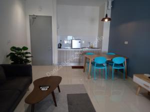 a living room with a couch and a table and chairs at DanZaStay2@CoreSoHo - nearby KLIA in Sepang